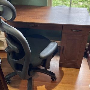 Brown desk with rolling chair.